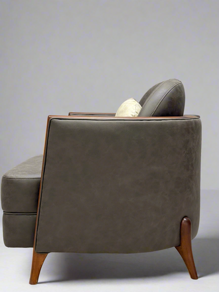 Bown leather armchair with wooden legs on a light gray background